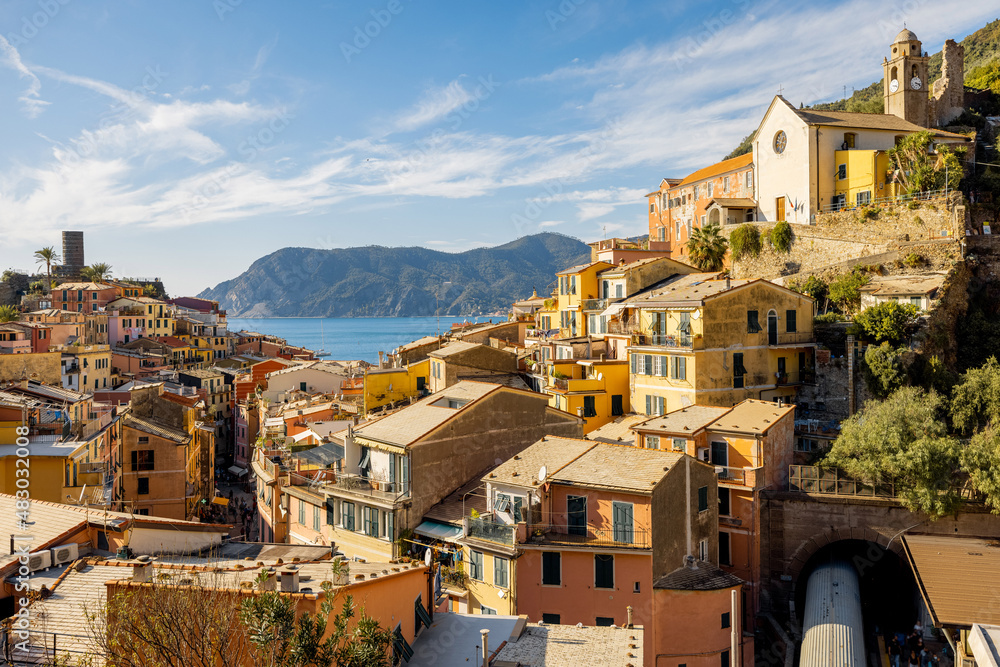 Landscape of Vernazza village with colorful old houses and church on the hill at sunny day. Famous village at Cinque Terre National Park at coastline in northwestern of Italy