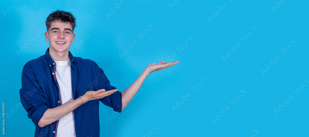 smiling young teenage boy isolated pointing background with space smiling young teenage boy isolated pointing background with space