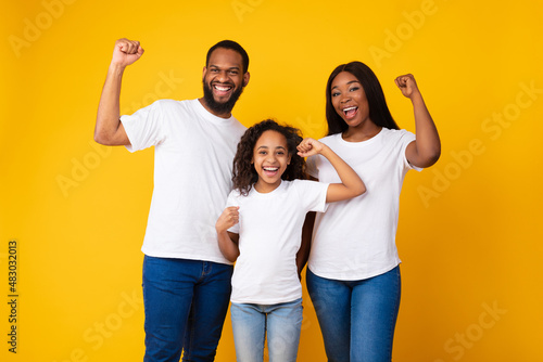 Portrait of emotional black family shaking fists at studio