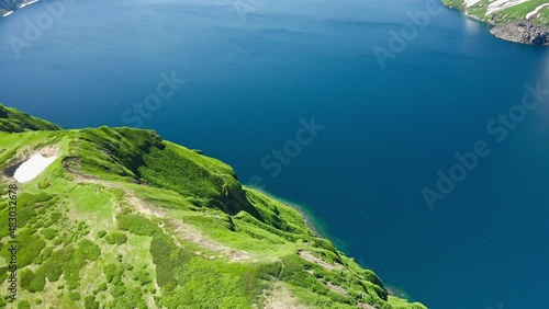 Aerial panorama. Drone flight high above blue water bay, wilderness green hills