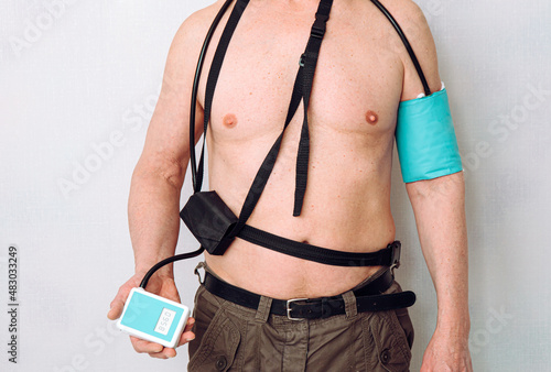 Canvas Print Body of a middle aged man using portable Ambulatory Blood Pressure Monitor (ABPM) for taking measurements during normal daily activities at home