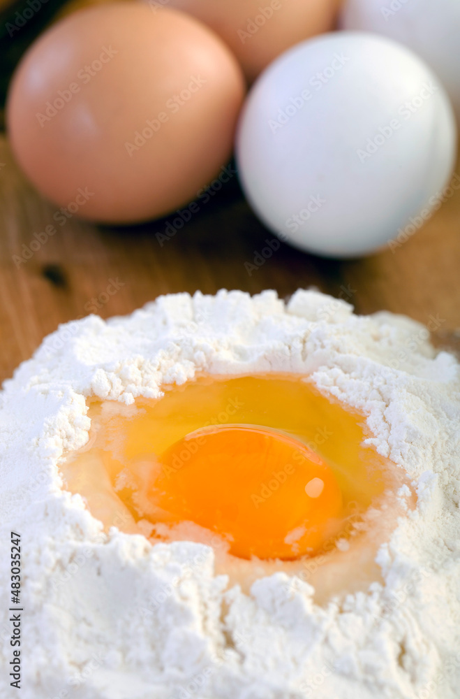 Egg in Flour with Eggs on Wooden Table Egg in Flour with Eggs on Wooden Table