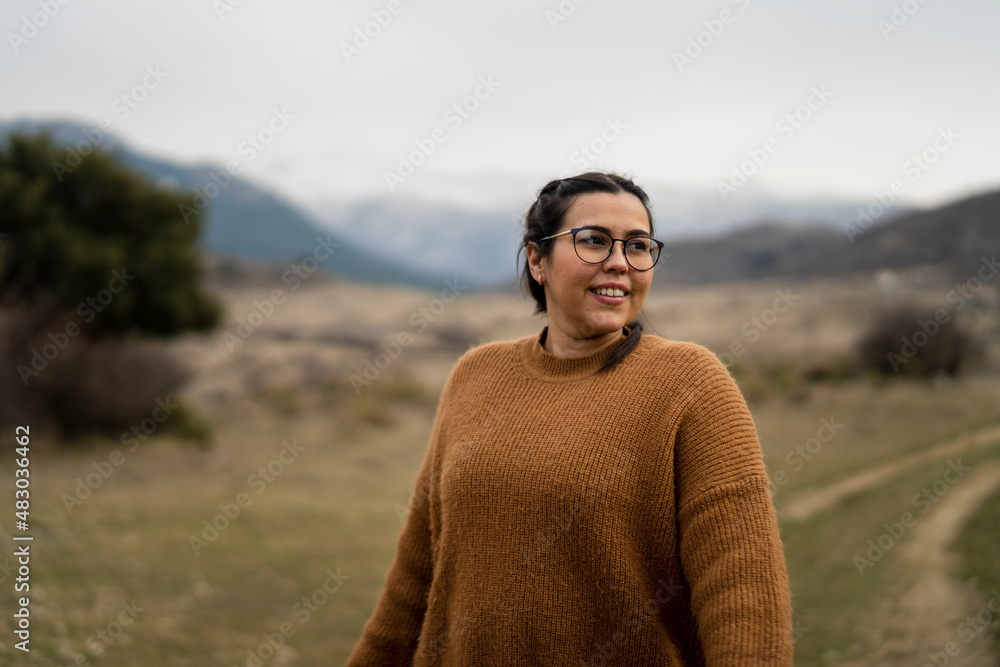 Chica guapa bajita con pelo moreno y gafas paseando por camino de tierra con la sierra nevada de fondo Chica guapa bajita con pelo moreno y gafas paseando por camino de tierra con la sierra nevada de fondo