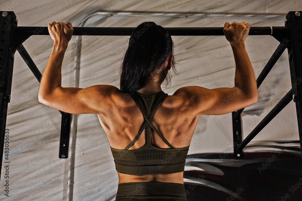 Fototapeta premium A beautiful woman in the gym practicing trapeze exercises