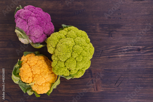 Fresh colorful cauliflowers over a rustic wood