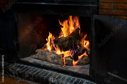Chimenea encendida con fuego y madera chamuscada