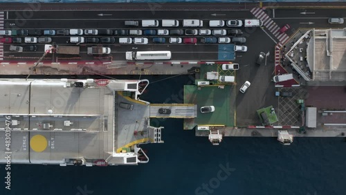 Aerial: cars disembarking from ferry ship docked in port. White fuel cistern truck refueling ferry boat in harbour. Transportation in Atlantic ocean between Canary islands. Drone view from above