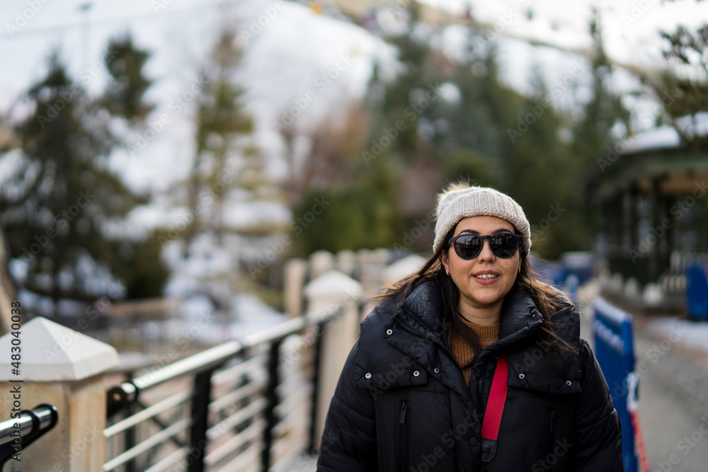 Chica guapa andando por estación de esquí con la nieve de fondo en la montaña Chica guapa andando por estación de esquí con la nieve de fondo en la montaña