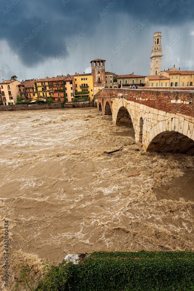 Verona, Ponte Pietra (Stone bridge), I century B.C, and Adige river in flood after several violent storms. UNESCO world heritage site, Veneto, Italy, Europe.