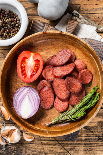 Turkish breakfast with Fried sausage sucuk on a rustic plate. Wooden background. Top view