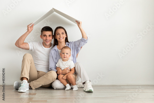 Family Housing. Happy Parents With Cute Infant Baby Sitting Under Cardboard Roof © Prostock-studio