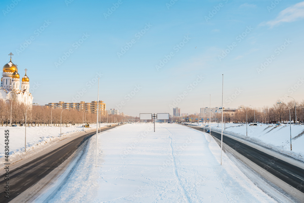 Fototapeta premium Panorama of wide streets in the city of Togliatti in winter with a view of the church and empty billboards. Togliatti, Russia - 4 Jan 2022
