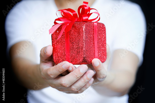 Fototapeta Naklejka Na Ścianę i Meble -  man holding red gift box with sentimental value Ready to give to your loved ones on your special day. and Valentine's Day