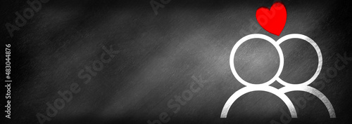 Fotografie A heart above two people drawn on a blackboard background