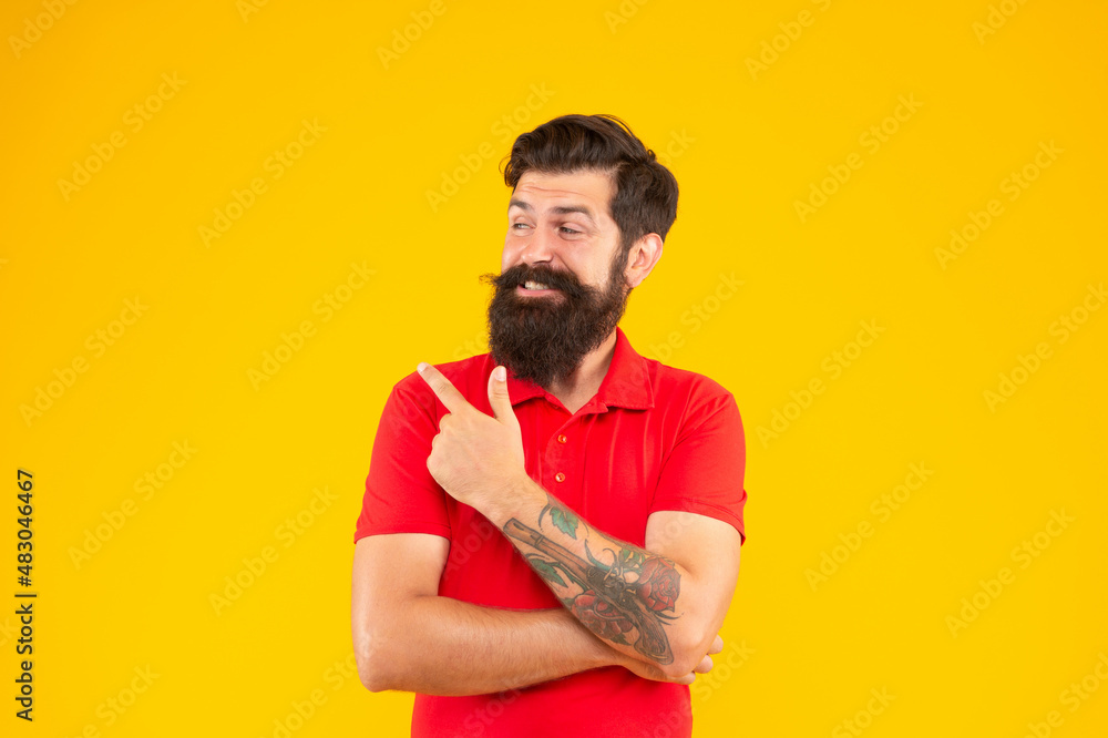 happy hipster male with beard pointing finger on yellow background, mens beauty happy hipster male with beard pointing finger on yellow background, mens beauty