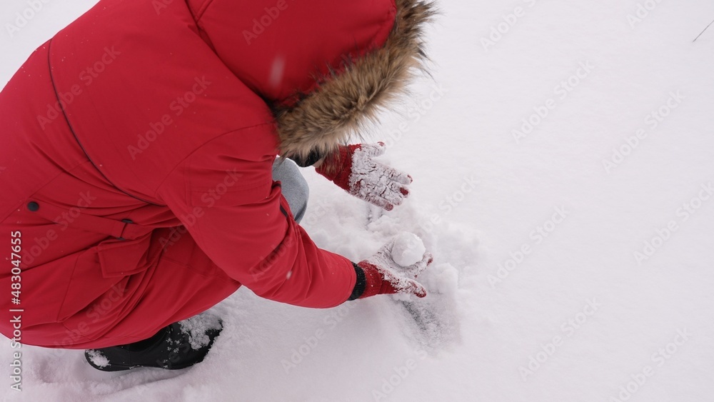 Φωτογραφία Close-up top view stock photography of woman picking up fresh white snow from ground to make snow balls