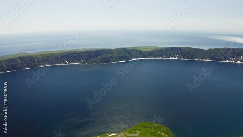 Birds eye panorama. Drone circles over blue water lagoon, misty endless horizon