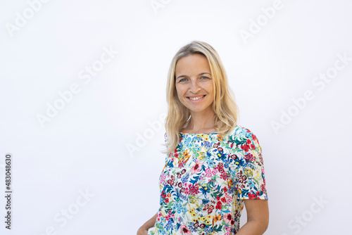 beautiful young woman with blond hair and flower shirt posing in front of white background