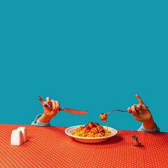 Food pop art photography. Female hands tasting spaghetti with meatballs on plaid tablecloth isolated on bright blue background. Vintage, retro style interior