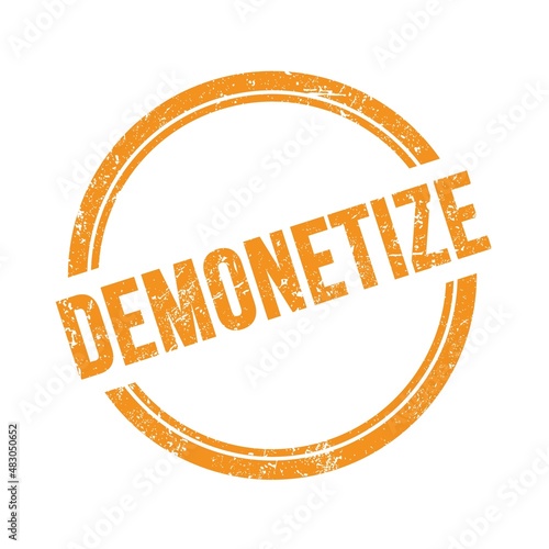 DEMONETIZE text written on orange grungy round stamp. photo