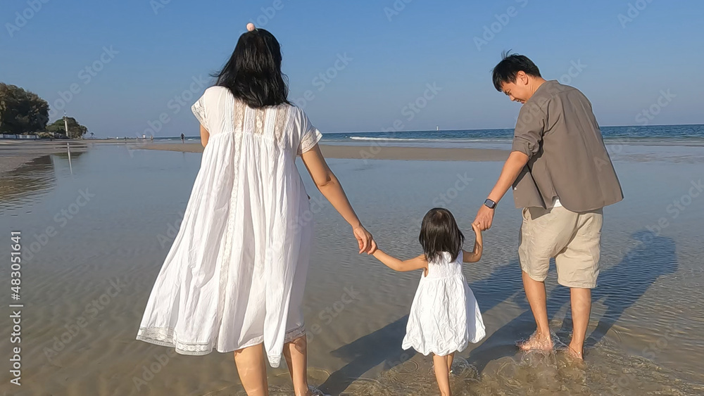Family walking by the sea in vacation.