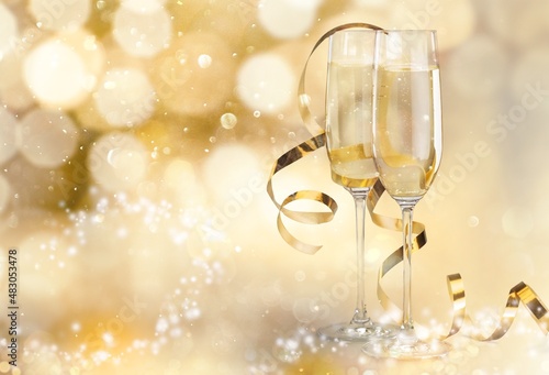 Two champagne flutes on beautiful gold shiny background