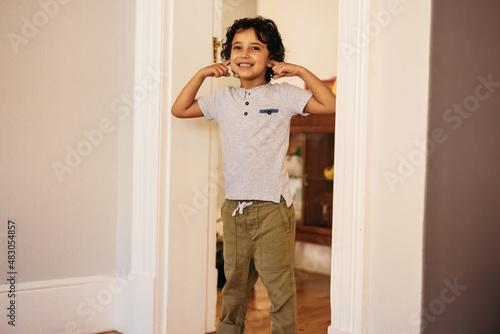 Happy young boy covering his ears