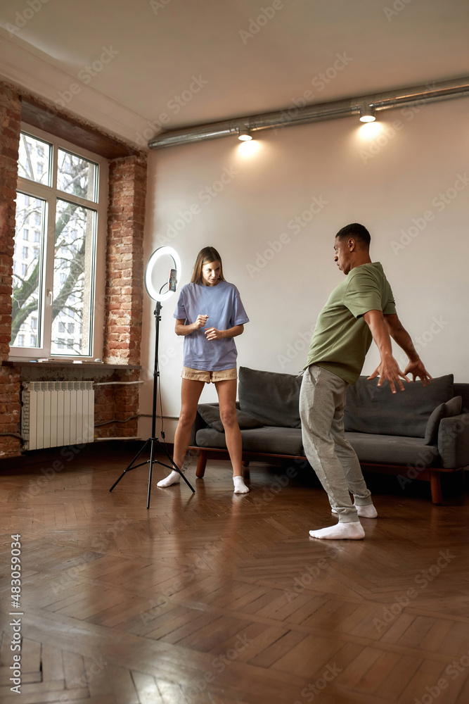 Fototapeta premium Girl showing guy how dancing for video challenge