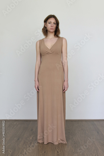 Woman in long beige cotton dress. Comfortable minimal suistainable fashion design. photo