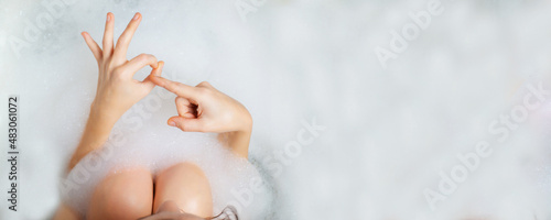 Female masturbation, bathroom sex concept. Female hands in a bath with foam depict erotic gestures. Sexual gratification in the bath. photo
