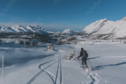 An unrecognizable male hiker wearing snowshoes running in the French Alps on a cold winter day (L'Enclus, Devoluy, Hautes-Alpes)
