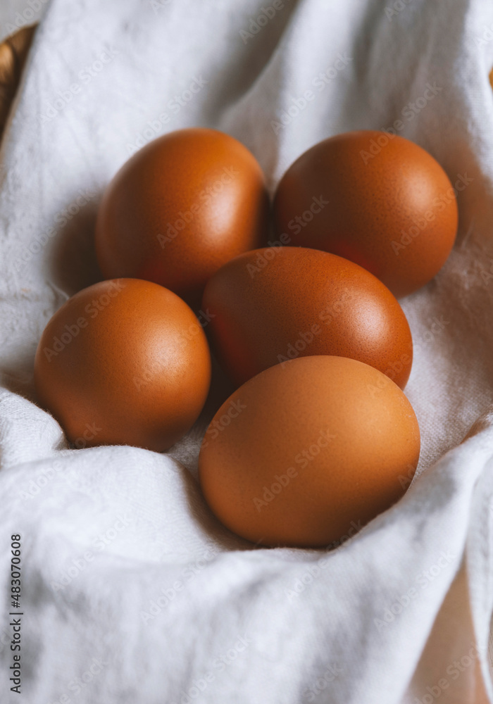 chicken eggs in a wicker basket covered with a linen towel are chicken eggs in a wicker basket covered with a linen towel are