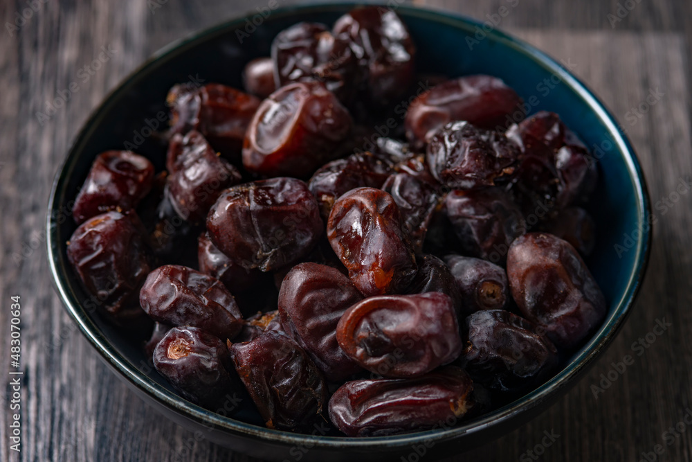 Mix of dates and nuts in plate on a white wood background .healthy food Mix of dates and nuts in plate on a white wood background .healthy food