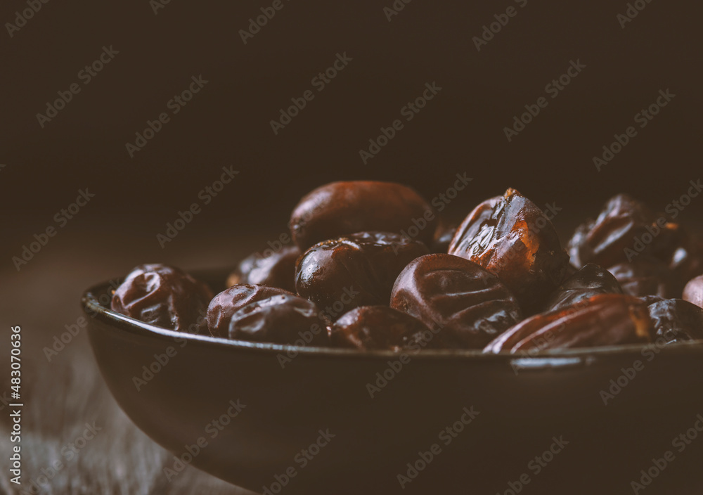 Mix of dates and nuts in plate on a white wood background .healthy food