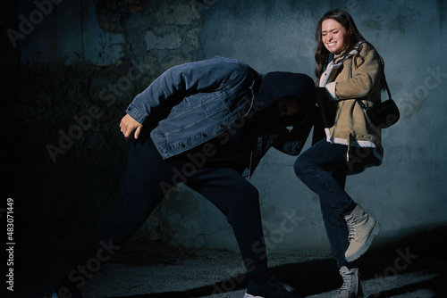 Woman defending herself from attacker outdoors at night