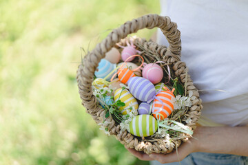 Easter egg hunt in spring garden. Funny teen girl with eggs basket and bunny ears on Easter egg hunt in sunny spring garden. Celebrating Easter. Happy easter card