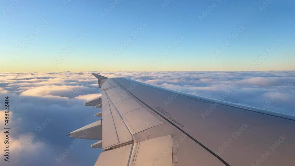 views from the window of an airplane in mid-flight, wing passing over the clouds take off views from the window of an airplane in mid-flight, wing passing over the clouds take off