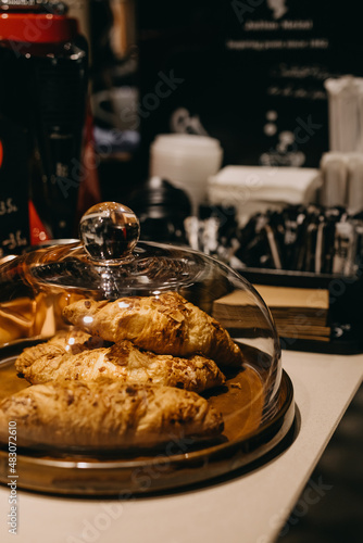 Closeup of a wooden tray with fresh baked almond croissants. 