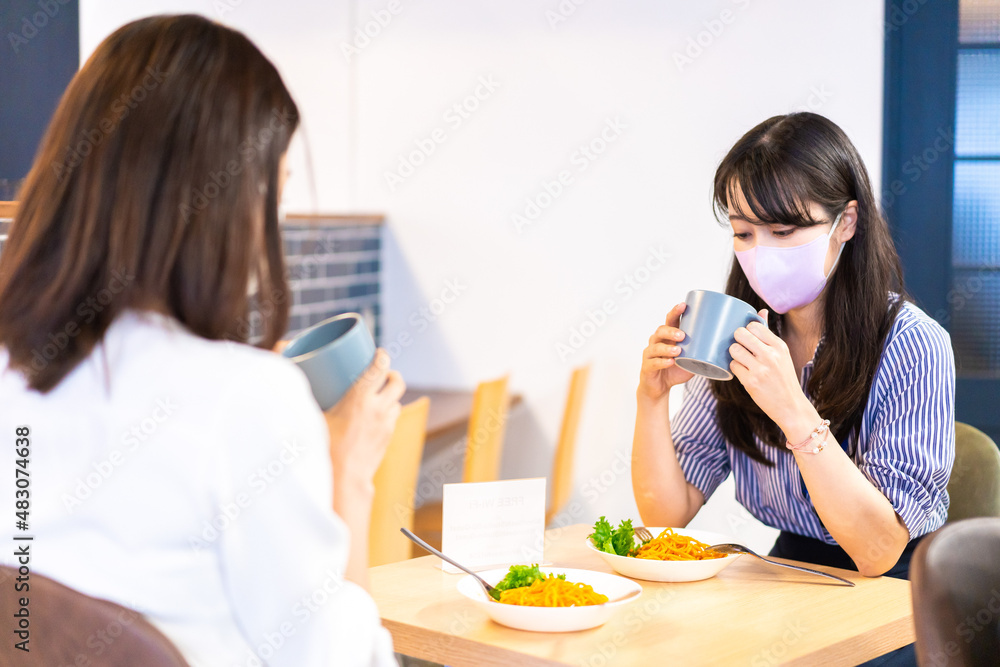 マスクをしてランチをする2人の若い女性