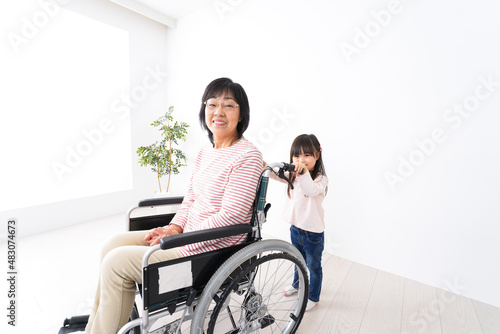 車椅子に乗るおばあちゃんと女の子 © maroke