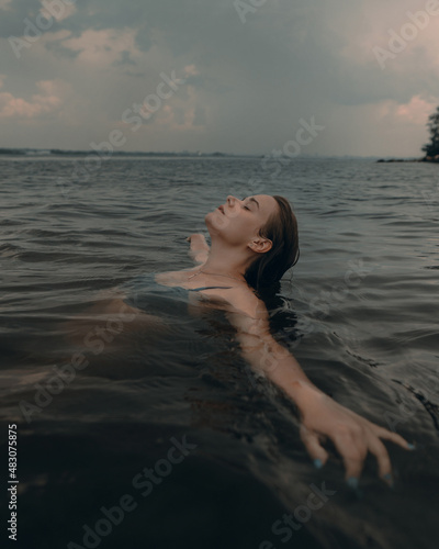 Girl swims relaxed in a beautiful mountain lake