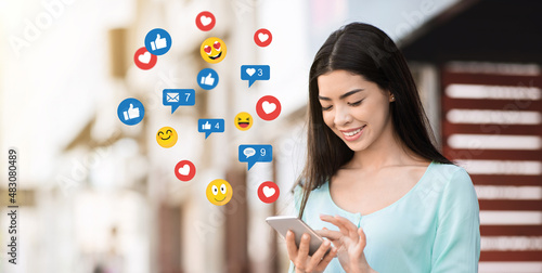 Canvas Print Smiling millennial asian woman surfing in internet in social networks and blog,