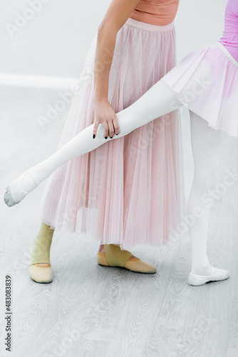 cropped view of girl practicing ballet elements near dance teacher photo