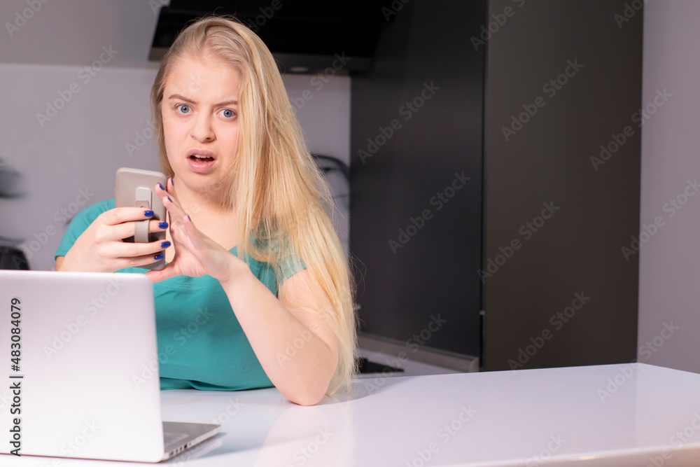 Young businesswoman in green using smartphone. On desk is laptop. Girl working, learning online. Social media, network. Online marketing, education. Young businesswoman in green using smartphone. On desk is laptop. Girl working, learning online. Social media, network. Online marketing, education.