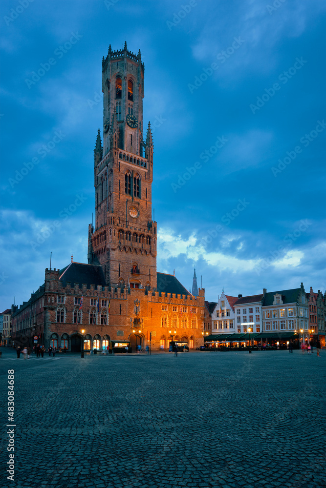 Belfry tower famous tourist destination and Grote markt square in Bruges, Belgium on dusk in twilight