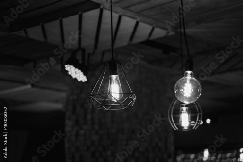 Black and white photo of metal lamps with light bulb, loft