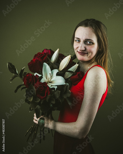 young beautiful brunette girl of European appearance with flowers on a green background