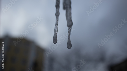 Icicle in the window against a cloudy background