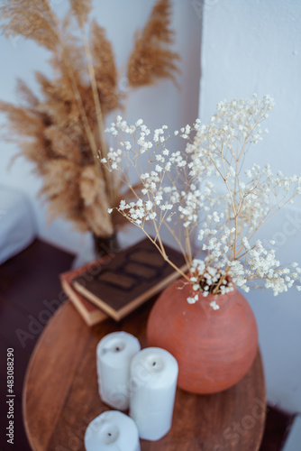 coffee table decorated with a vase of dried flowers,candles and books,aesthetics