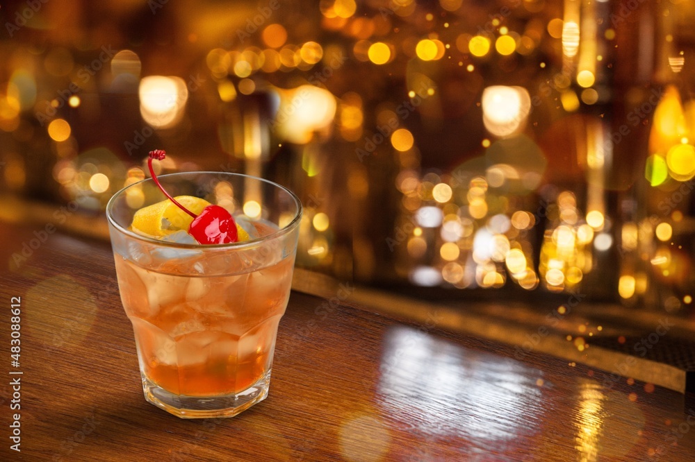 Glass of alcohol whiskey on the bar counter. Blurred interior of bar at the background. Glass of alcohol whiskey on the bar counter. Blurred interior of bar at the background.
